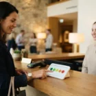 Gość hotelu ocenia pobyt na panelu ankietowym przy recepcji